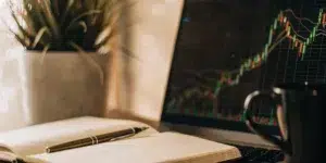 Keyword research tools on laptop with notebook and pen.