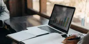 SEO budget plan on a laptop with graphs and notebooks.
