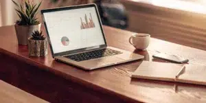 Marketing consultant's desk with laptop, notebook, and phone.
