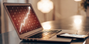 Upward graph on a laptop showing increased ROI from the best AI tool for Meta ads.