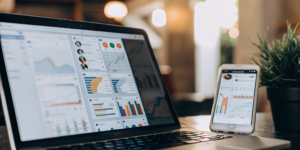 A laptop and phone displaying charts and data for social media marketing trends.