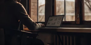 Person using KWFinder on a laptop to find keywords and check their SEO difficulty score.